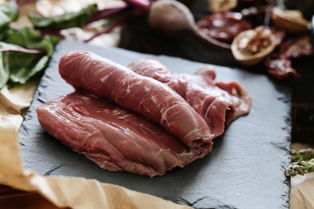 Carne cruda con ingredientes para cocinar