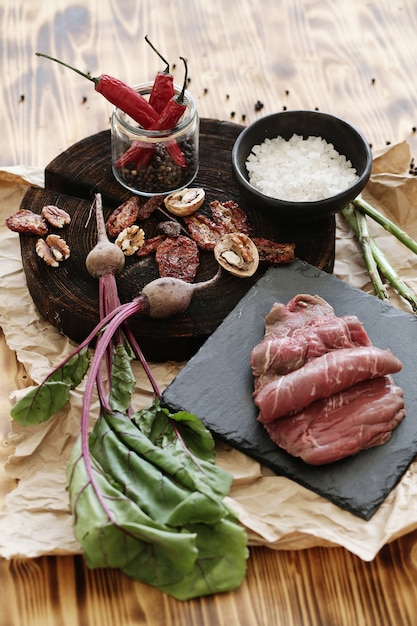 Carne cruda con ingredientes para cocinar