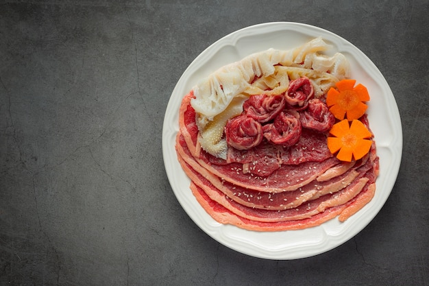 Foto gratuita carne cruda en un plato blanco para el menú de olla caliente shabu