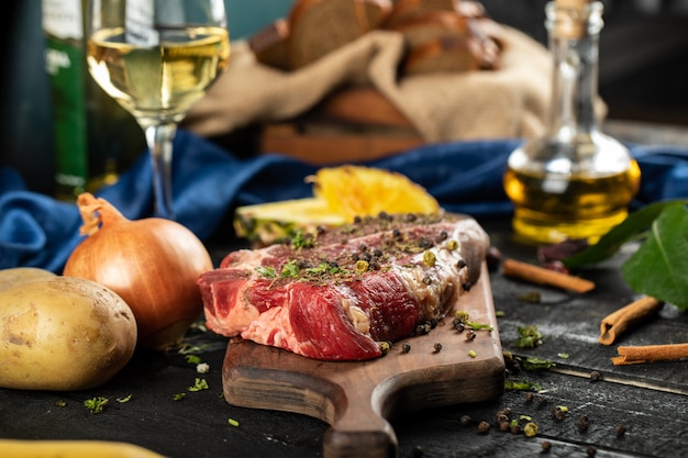 Foto gratuita carne cruda en una tabla de madera con hierbas y especias.