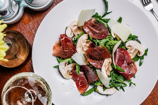 Foto gratuita carne curada con rúcula y parmesano