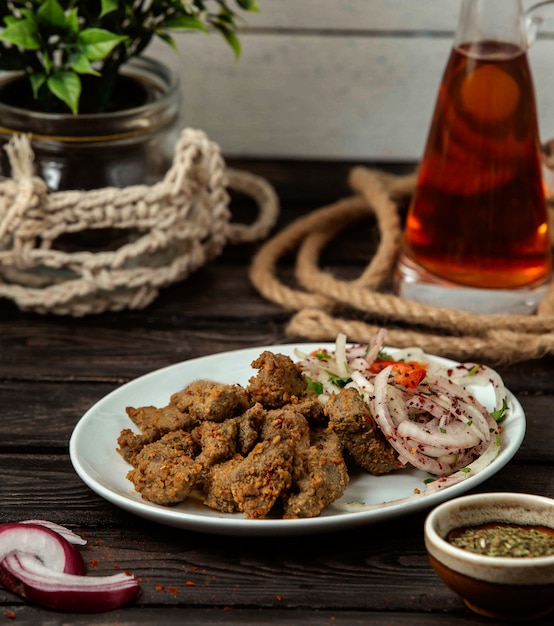 Foto gratuita carne con especias y cebolla con zumaque en una mesa de madera