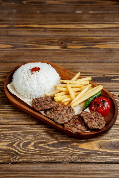 Carne frita con arroz y papas fritas