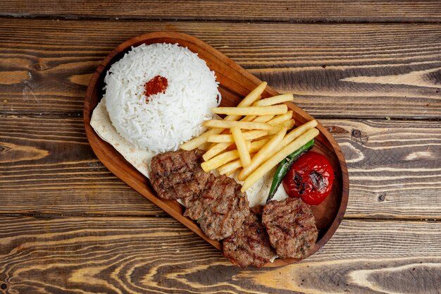 Carne frita con arroz y papas fritas