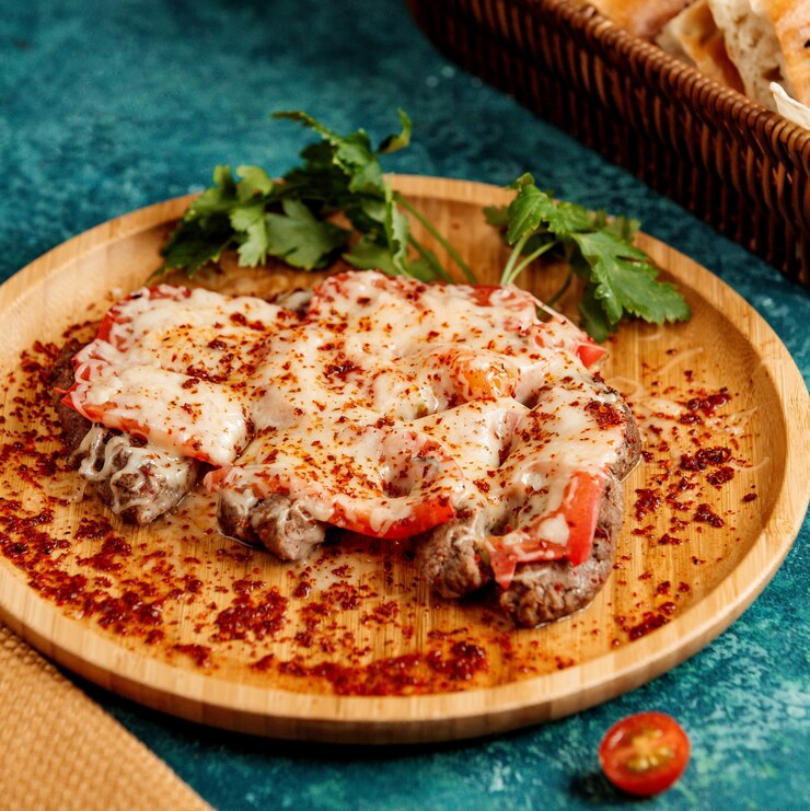 Foto gratuito carne frita cubierta con tomates y queso rallado.