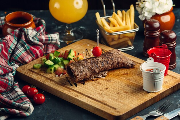 Carne frita envuelta en un rollo de ensalada fresca y papas fritas