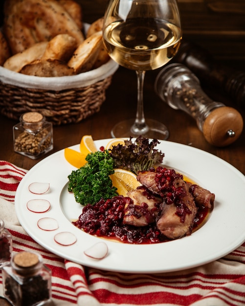 Foto gratuita carne frita con granada y copa de vino.