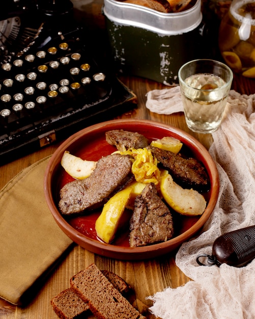 Carne frita con membrillo en una cazuela de barro