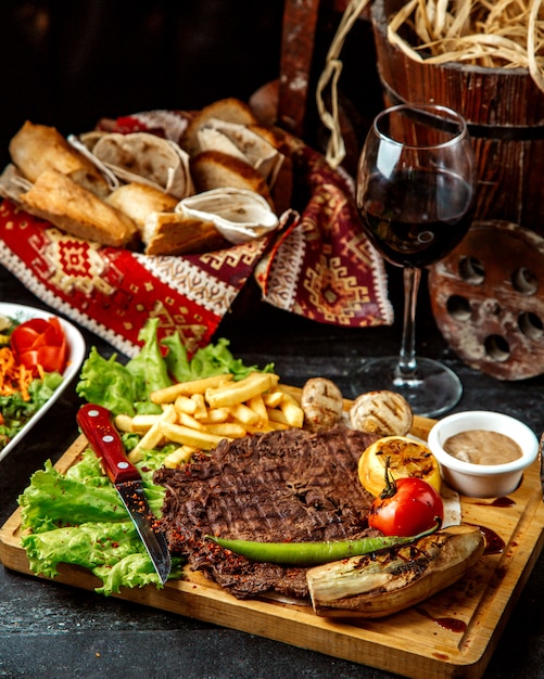 Carne frita con papas fritas y vino tinto.