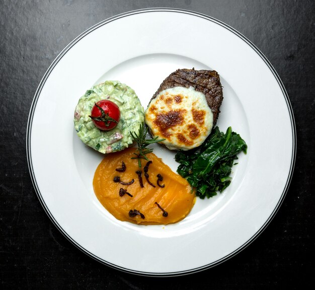 Carne frita con queso crema y ensalada.