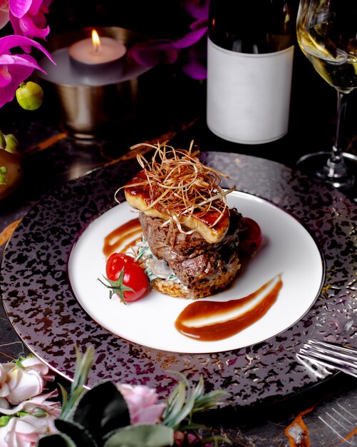 Carne frita servida con tomate, salsa y queso ahumado.