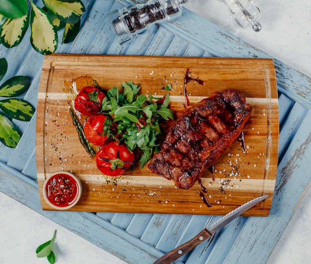 carne frita con verduras en la vista superior del tablero de madera