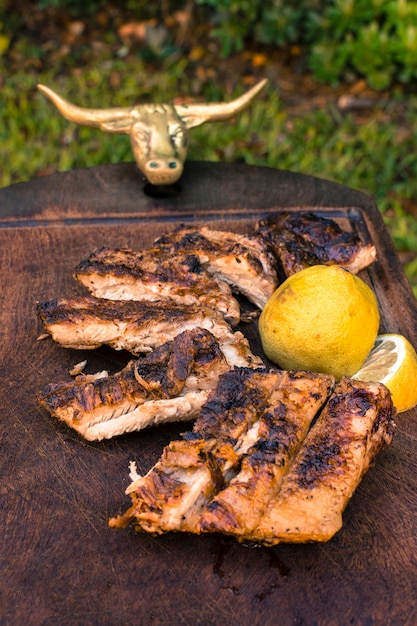 Foto gratuita carne a la parrilla cortada y rodajas de limón en la mesa