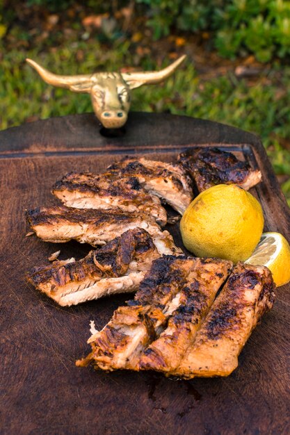 Carne a la parrilla cortada y rodajas de limón en la mesa