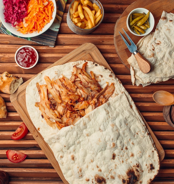 Carne a la parrilla con lavash sobre una plancha de madera.