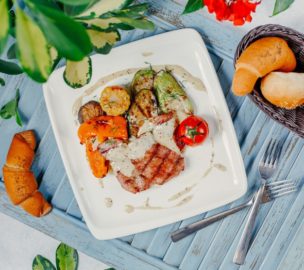 Carne a la parrilla con verduras a la parrilla, arroz y tomate.