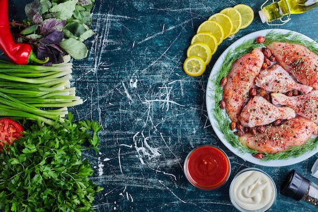 Carne de pollo frito en una tabla de madera con salsas y verduras.