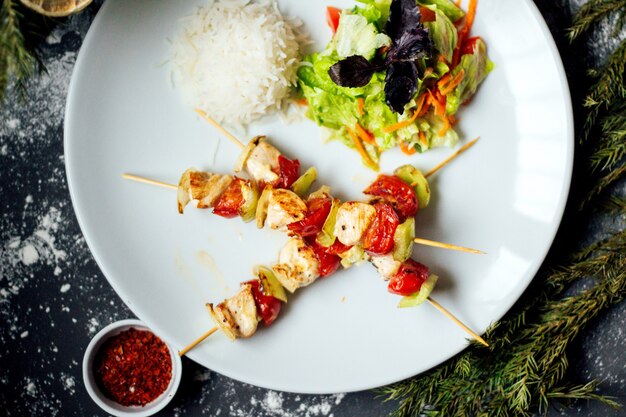 Carne de pollo frito y tomate con arroz.