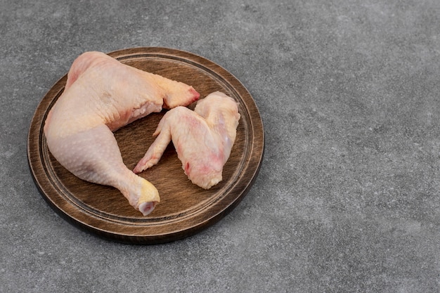 Carne de pollo orgánica fresca sobre tabla de madera