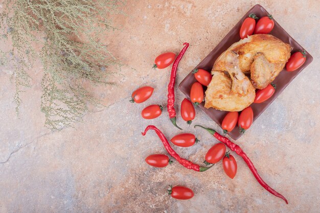 Carne de pollo a la parrilla con chiles rojos y tomates cherry