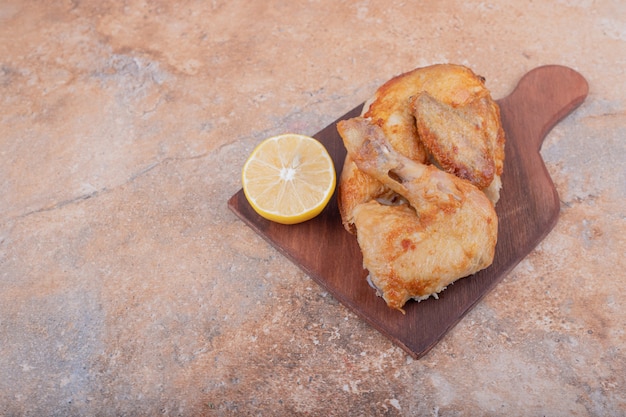 Carne de pollo a la plancha con limón en un plato de madera