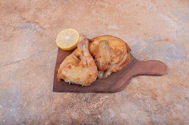 Carne de pollo a la plancha con limón en un plato de madera