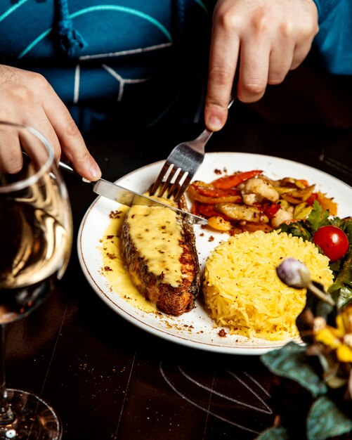 Carne con queso derretido encima y arroz