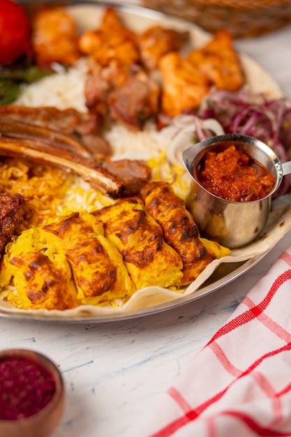 Carne de res, kebab de pollo, barbacoa con papas asadas, a la parrilla, tomates y servido con arroz.