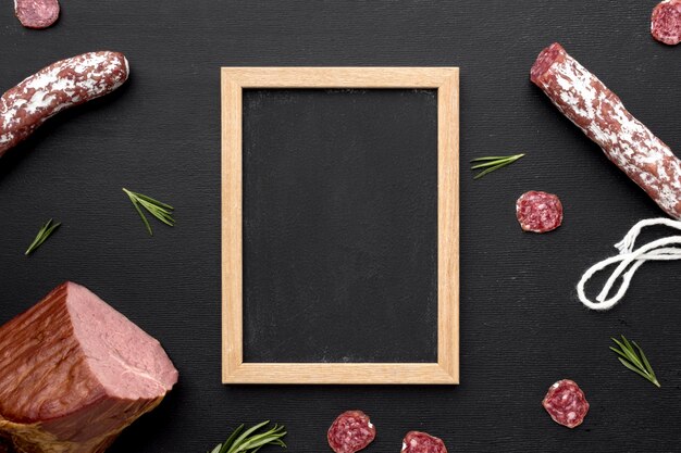 Carne de salami y filete con marco en el escritorio