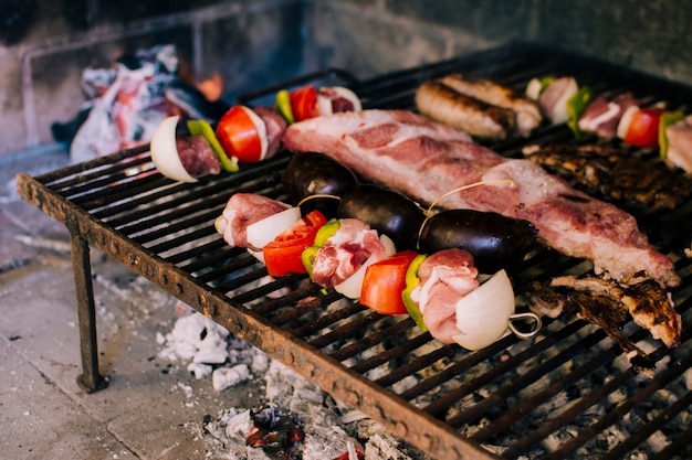 Carnes y verduras a la parrilla sobre carbón caliente.