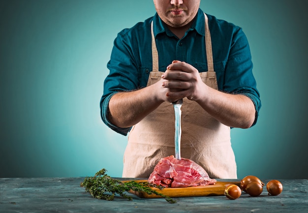 Carnicero cortando carne de cerdo en la cocina