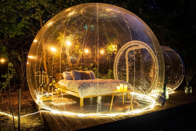 Carpa burbuja transparente en glamping por la noche