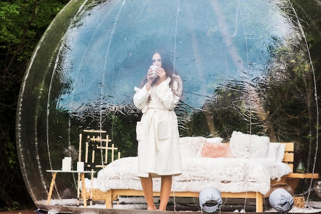 Carpa burbuja transparente y mujer en glamping