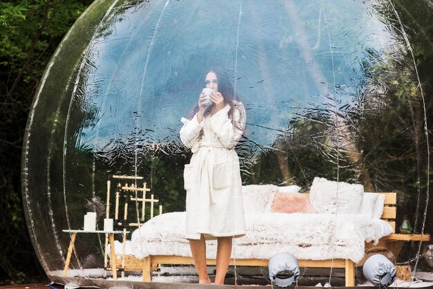 Carpa burbuja transparente y mujer en glamping