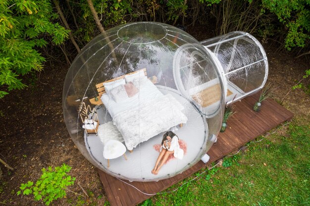 Carpa burbuja transparente y mujer en glamping