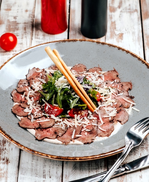 Carpaccio de carne con verduras sobre la mesa