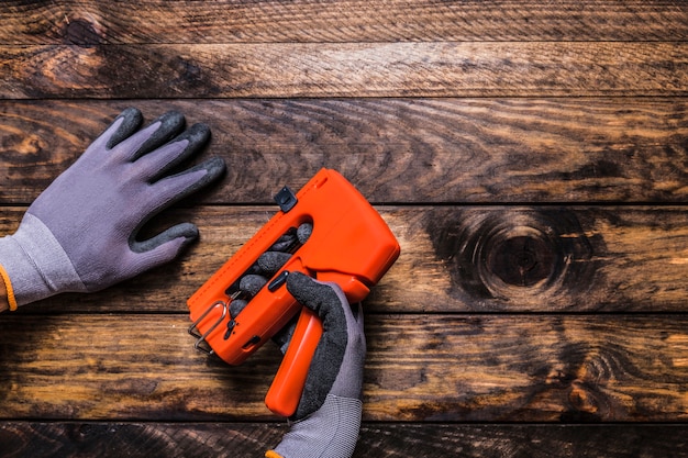 Carpenter con pistola de grapas en la mesa de madera