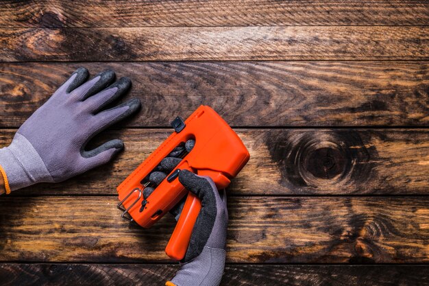 Carpenter con pistola de grapas en la mesa de madera