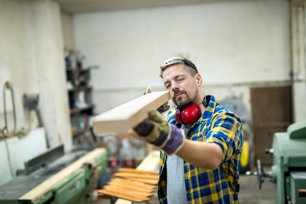 Carpintero comprobando la calidad de la pieza de muebles de madera