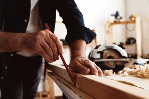 Foto gratis carpintero hace marcas de lápiz en una tabla de madera