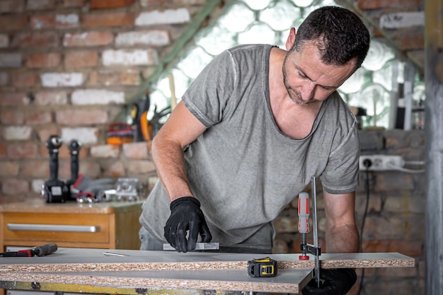 Carpintero haciendo trabajos de madera con herramienta de mano de sujeción en su taller.