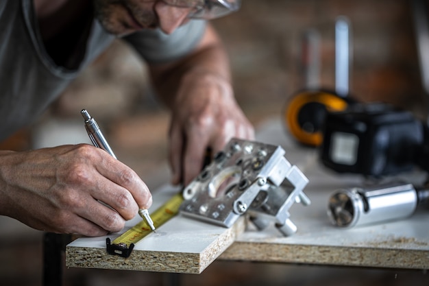 Un carpintero en el proceso, una herramienta profesional para taladrar con precisión en madera.