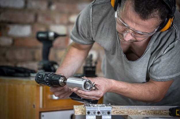 Carpintero profesional trabajando con un taladro de bisagra, trabajando con madera