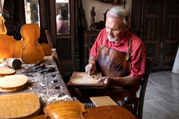 Foto gratuita carpintero senior trabajando en su antiguo taller