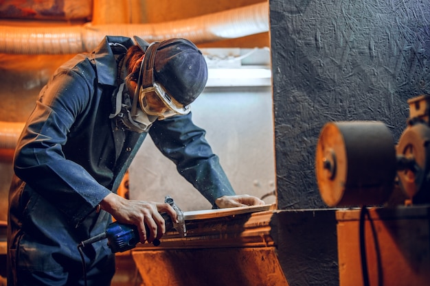 Foto gratuita carpintero con sierra circular para cortar tablas de madera. detalles de construcción de trabajador masculino o hombre práctico con herramientas eléctricas