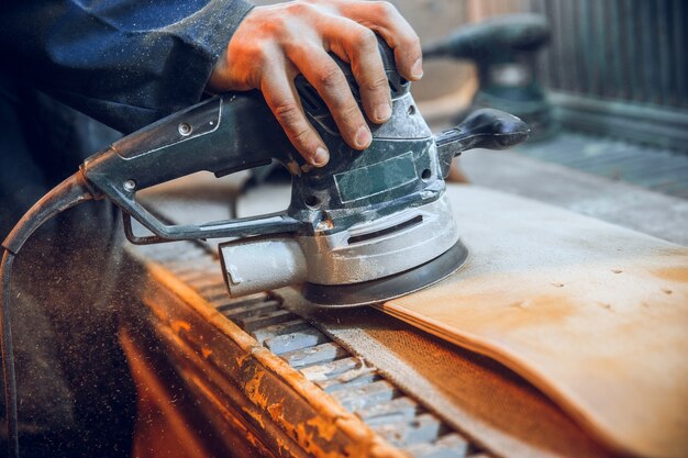 Carpintero con sierra circular para cortar tablas de madera. Detalles de construcción de trabajador masculino o hombre práctico con herramientas eléctricas