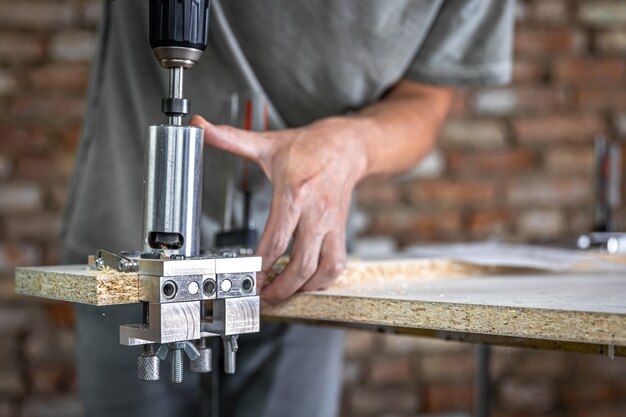 El carpintero trabaja como una herramienta profesional para perforar madera.