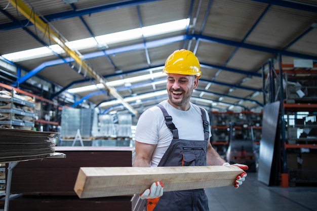 Carpintero trabajador de fábrica sosteniendo material de madera y trabajando en la industria del mueble