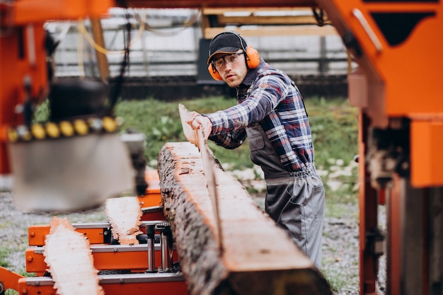 Carpintero trabajando en un aserradero en una fabricación de madera