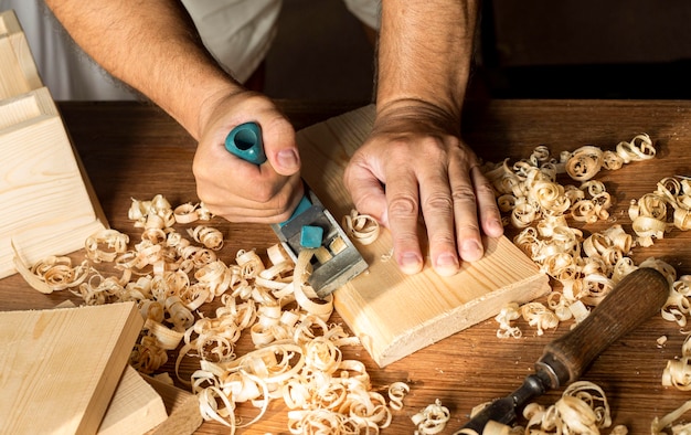 Carpintero trabajando con sus manos desnudas sobre madera